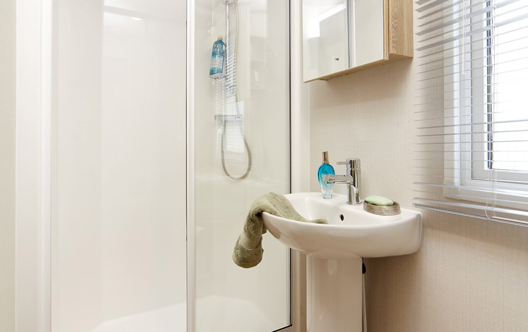 shower room with a sink and mirrored unit in the Bayview caravan