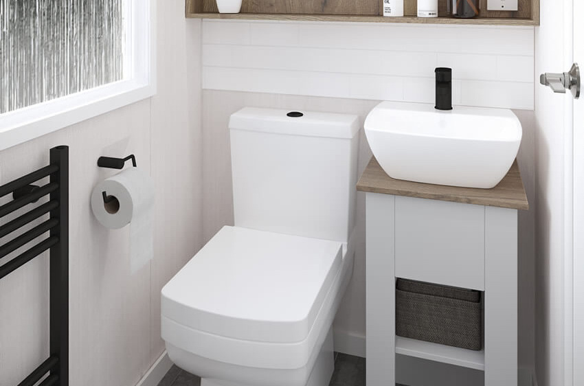 A modern toilet and sink in the Margaux caravan